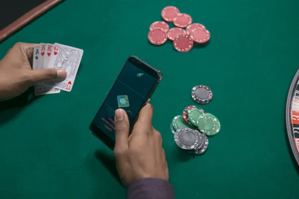 Gambar dekat syiling emas jatuh di sekitar roda rolet berputar, mewakili aksi kasino yang mendalam di FOOTBALL BET.