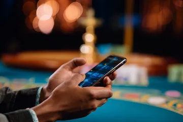 A player using their smartphone during a festive local event, representing FOOTBALL BET’s fully mobile-friendly casino.